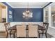 Dining room with wainscoting and a dark wood table with seating for six, and an abstract painting on the wall at 521 Village Loop Dr, Apex, NC 27502