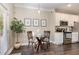 Cozy kitchen and dining area with stainless steel appliances, a glass table, and houseplant at 521 Village Loop Dr, Apex, NC 27502