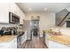 Galley style kitchen boasts stainless appliances, granite countertops, and dark hardwood floors at 521 Village Loop Dr, Apex, NC 27502