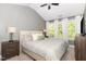 Vaulted main bedroom with large windows, neutral walls and carpet, and a comfortable upholstered bed at 521 Village Loop Dr, Apex, NC 27502