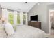 Tranquil main bedroom boasts large windows, neutral walls and carpet, and a comfortable upholstered bed at 521 Village Loop Dr, Apex, NC 27502