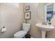 Charming powder room featuring a pedestal sink, decorative accents and artwork, and neutral wall paint at 521 Village Loop Dr, Apex, NC 27502