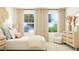 Bright bedroom features large windows, neutral decor, chair, dresser, and comfortable bed at 529 Morning Light Dr, Angier, NC 27501