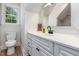 This bathroom includes a white vanity, ample storage, a decorative mirror, and a modern toilet with wood-look flooring at 5337 Nc Hwy 96, Selma, NC 27576