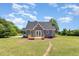 Exterior rear view displays a cozy home with a new deck, gray siding, lush lawn, and mature trees at 5337 Nc Hwy 96, Selma, NC 27576