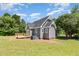 Side view shows the home's exterior, wooden deck, well-kept lawn, and central air unit near beautiful, shady trees at 5337 Nc Hwy 96, Selma, NC 27576