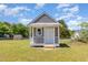 Charming outdoor storage shed with a covered porch, gray siding, and a white trim in a spacious backyard at 5337 Nc Hwy 96, Selma, NC 27576