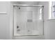 Bathroom featuring a white tub with clear sliding glass doors and modern fixtures at 5456 Grand Traverse Dr, Raleigh, NC 27604
