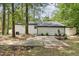 Rear view of a home featuring a mix of white siding and brick, with a paved patio and low-maintenance landscaping at 620 Wexford Dr, Raleigh, NC 27603