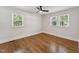 Bedroom featuring hardwood floors, fresh white paint, a ceiling fan, and natural light from the windows at 620 Wexford Dr, Raleigh, NC 27603
