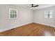 Bedroom featuring hardwood floors, fresh white paint, a ceiling fan, and natural light from the windows at 620 Wexford Dr, Raleigh, NC 27603