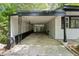 Covered carport area with white brick walls, decorative steel support beams, and secure gated access at 620 Wexford Dr, Raleigh, NC 27603