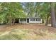 Charming single-story home featuring classic curb appeal with black accents and mature trees in the front yard at 620 Wexford Dr, Raleigh, NC 27603