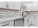Close-up of a kitchen featuring stainless steel appliances, white marble countertops, and newly updated white cabinets at 620 Wexford Dr, Raleigh, NC 27603