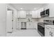 Updated kitchen with white cabinetry, marble countertops, stainless appliances, and a modern backsplash design at 620 Wexford Dr, Raleigh, NC 27603