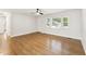 Spacious living room with newly refinished wood floors, a ceiling fan, and lots of natural light from the windows at 620 Wexford Dr, Raleigh, NC 27603