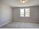 This bedroom has neutral walls, carpet, one window, and a overhead light at 63 W Victoria Ridge Dr # 31, Selma, NC 27576