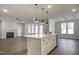 A kitchen island overlooks a living area with a fireplace and lots of natural light from large windows at 63 W Victoria Ridge Dr # 31, Selma, NC 27576