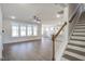 Open-concept living room with wood floors, large windows, and a staircase with a wooden handrail at 63 W Victoria Ridge Dr # 31, Selma, NC 27576