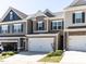 Two-story townhome featuring a spacious two-car garage and a well-maintained lawn at 6341 Grace Lily Dr, Raleigh, NC 27607