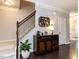 Elegant hallway featuring hardwood floors, staircase, and decorative display cabinet at 6341 Grace Lily Dr, Raleigh, NC 27607