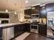 Well-lit kitchen with stainless steel appliances and dark wood cabinets at 6341 Grace Lily Dr, Raleigh, NC 27607