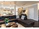 Inviting living room with dark brown sectional, leading to a bright kitchen and staircase at 6341 Grace Lily Dr, Raleigh, NC 27607
