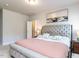 Spacious main bedroom featuring a tufted headboard and neutral colors with access to the bathroom at 6341 Grace Lily Dr, Raleigh, NC 27607