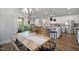 Open-concept dining room with hardwood floors and a modern chandelier, flowing into the living area and kitchen at 680 Beacon Hill Rd # 52, Lillington, NC 27546