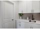 Laundry room features quartz countertops, undermount sink, tiled backsplash and white cabinets at 680 Beacon Hill Rd # 52, Lillington, NC 27546