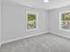 Bedroom with neutral colors, two windows, and soft carpet at 806 Martin Luther King Jr Dr, Smithfield, NC 27577