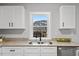Bright kitchen sink with granite counters, white cabinets and a sunlit window at 806 Martin Luther King Jr Dr, Smithfield, NC 27577