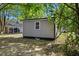 A view of the backyard, showing the back of the house, surrounded by lush trees and foliage at 806 Martin Luther King Jr Dr, Smithfield, NC 27577