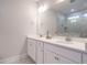 Bright bathroom featuring double vanity with white cabinets and quartz countertop, plus large mirror reflecting walk-in shower at 816 Still Willow Ln, Wendell, NC 27591