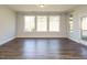 A large bonus room featuring hardwood floors and multiple windows, offering natural light and views of the outdoors at 816 Still Willow Ln, Wendell, NC 27591