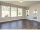 Spacious bonus room with hardwood floors, complemented by a large set of windows, and access to a screened porch at 816 Still Willow Ln, Wendell, NC 27591