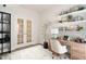 Bright home office featuring double french doors, floating shelves, and a wood desk with a comfortable upholstered chair at 816 Still Willow Ln, Wendell, NC 27591