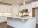 Bright kitchen with island, white cabinets, stainless appliances, and pendant lighting at 816 Still Willow Ln, Wendell, NC 27591