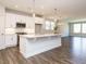 Bright kitchen with island, white cabinets, stainless appliances, and pendant lighting at 816 Still Willow Ln, Wendell, NC 27591