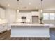Bright, modern kitchen with quartz island, white cabinetry, and stainless steel appliances at 816 Still Willow Ln, Wendell, NC 27591