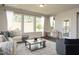 A cozy living room showcasing large windows, hardwood floors, a comfortable sofa, and stylish decor for a welcoming ambiance at 816 Still Willow Ln, Wendell, NC 27591