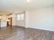 Spacious living area boasts hardwood floors, with a view of the modern kitchen and a bright window, perfect for entertaining at 816 Still Willow Ln, Wendell, NC 27591