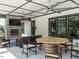 Cozy covered patio with stone fireplace, comfortable seating, and ceiling fans for relaxed outdoor living at 816 Still Willow Ln, Wendell, NC 27591