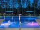 Stunning community pool illuminated at night with underwater lights, featuring lounge chairs and cabanas at 816 Still Willow Ln, Wendell, NC 27591
