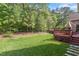 Well-maintained backyard with lush green grass, mature trees, and a wooden deck at 913 S South Bend Dr, Durham, NC 27713