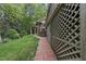 Exterior view of the home's backyard features a lattice trim, brick walkway, and luscious greenery at 927 Jones Wynd, Wake Forest, NC 27587