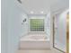 Bright bathroom with a soaking tub, glass block window and a separate shower at 927 Jones Wynd, Wake Forest, NC 27587