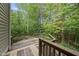 Wooden deck with a wooden railing and a lush tree canopy in the background at 927 Jones Wynd, Wake Forest, NC 27587