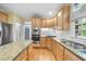 Bright kitchen boasts stainless steel appliances, granite countertops, and classic cabinetry at 927 Jones Wynd, Wake Forest, NC 27587