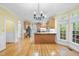 Open-concept kitchen and dining area with wood floors, light cabinets, and stainless steel appliances at 927 Jones Wynd, Wake Forest, NC 27587